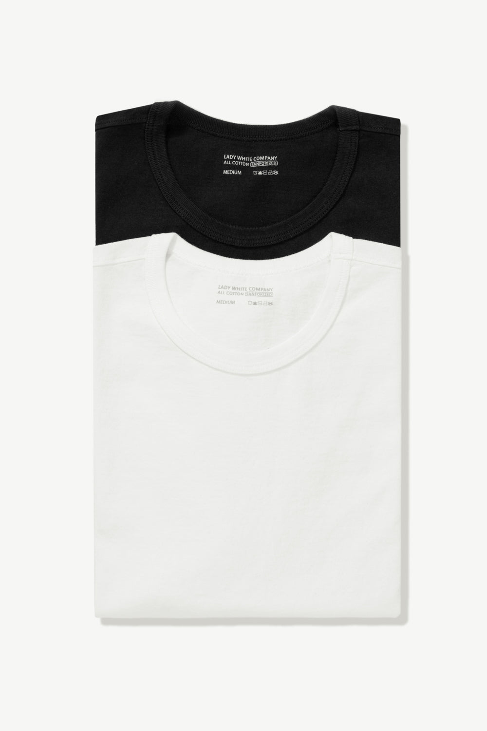Two LW101 Our T-shirts, stacked on top of each other, enclosed in a belly band