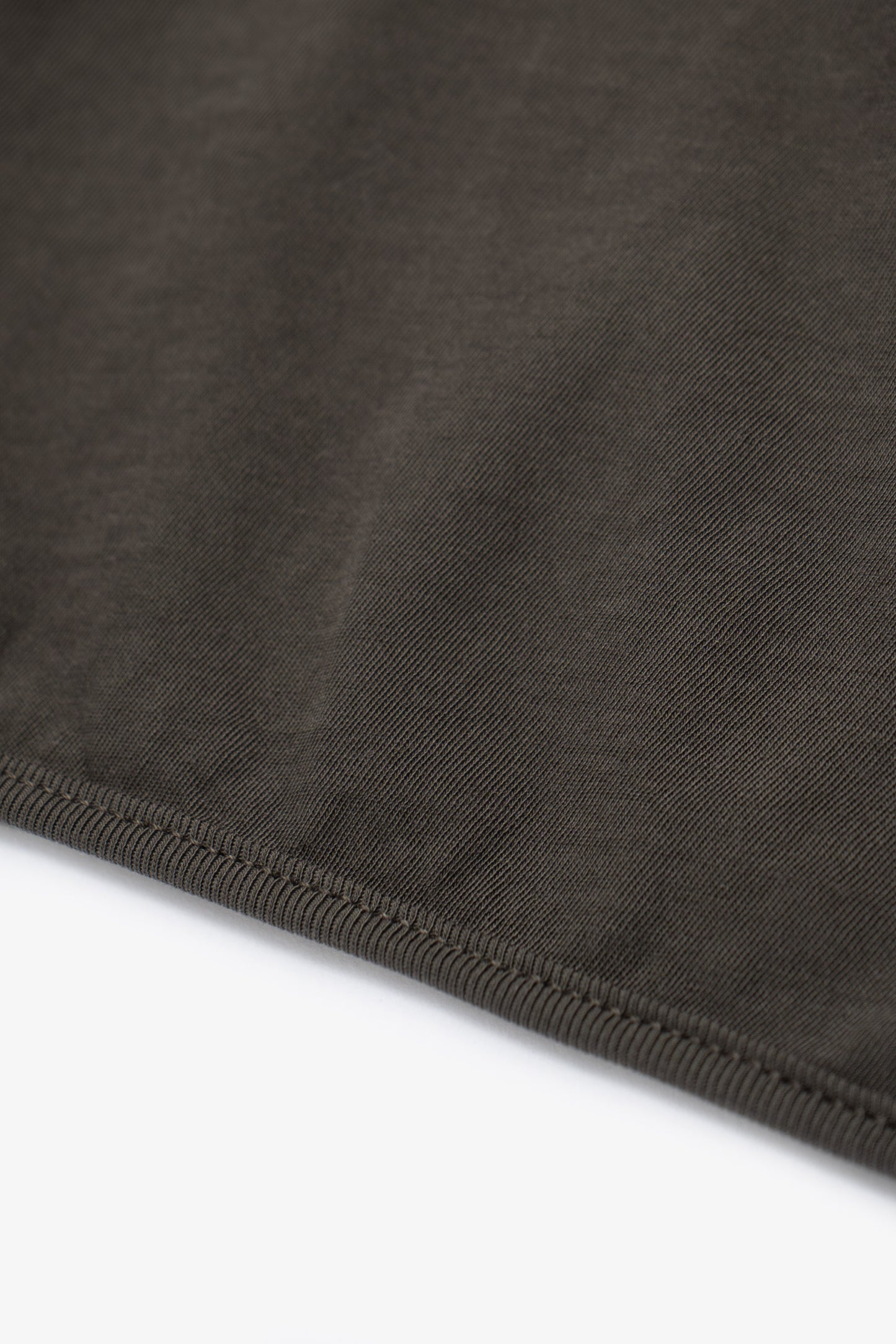 Hem detail of of the LW110 Dry-lite T-shirt in a greenish black, “Black Pine”