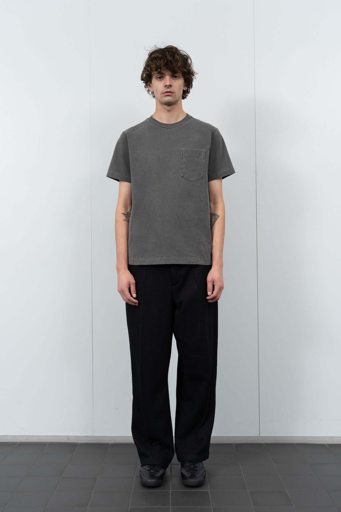 Model poses in LW1120 Balta Pocket T-shirt in grindle against a gray background