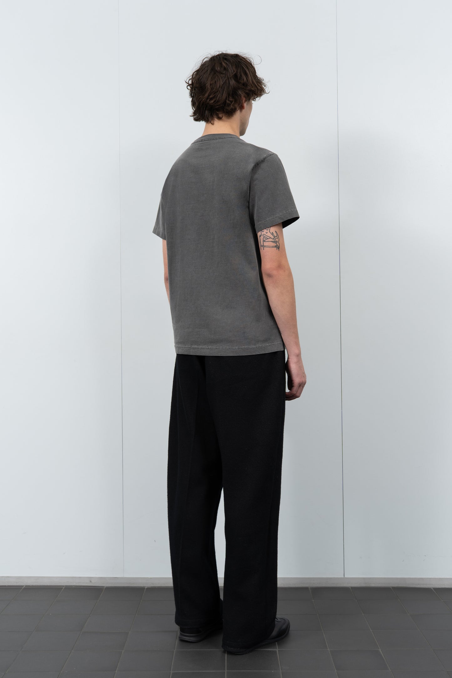 Model poses in LW1120 Balta Pocket T-shirt in grindle against a gray background