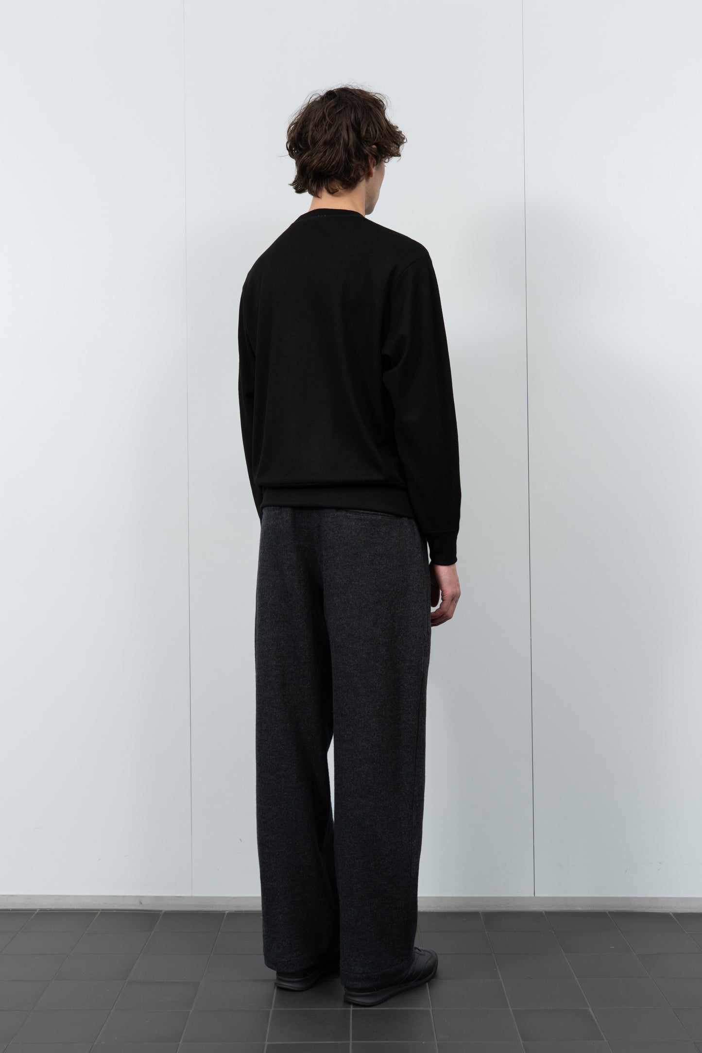 Model poses in LW601W Wool Jersey Sweater in black