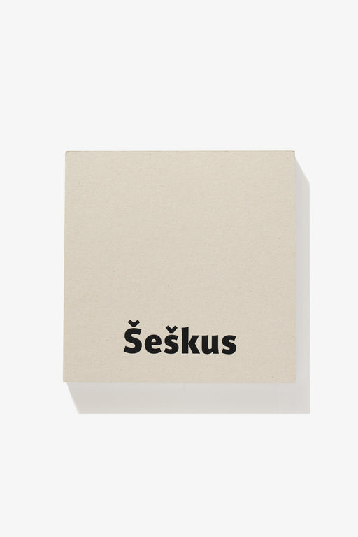 Full-length image of the cover of Algirdas Šeškus photography book, Grey But Not Grey. The surname “Šeškus” is printed in black against a grey background.