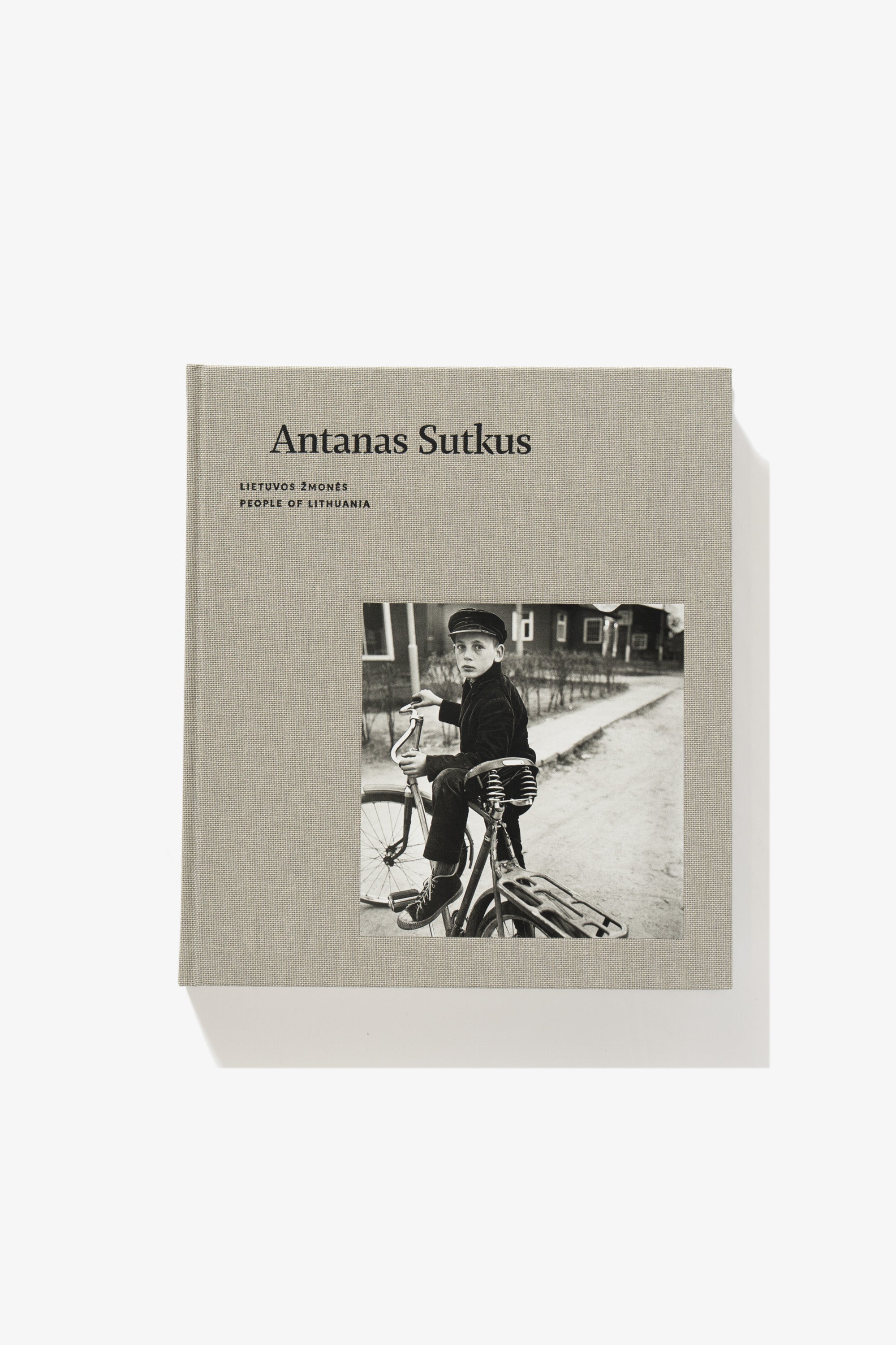 Full-length image of the cover of Antanas Sutkus’s photography book “People of Lithuania.” A boy on a bicycle is stopped, his body turned toward but not at the camera.
