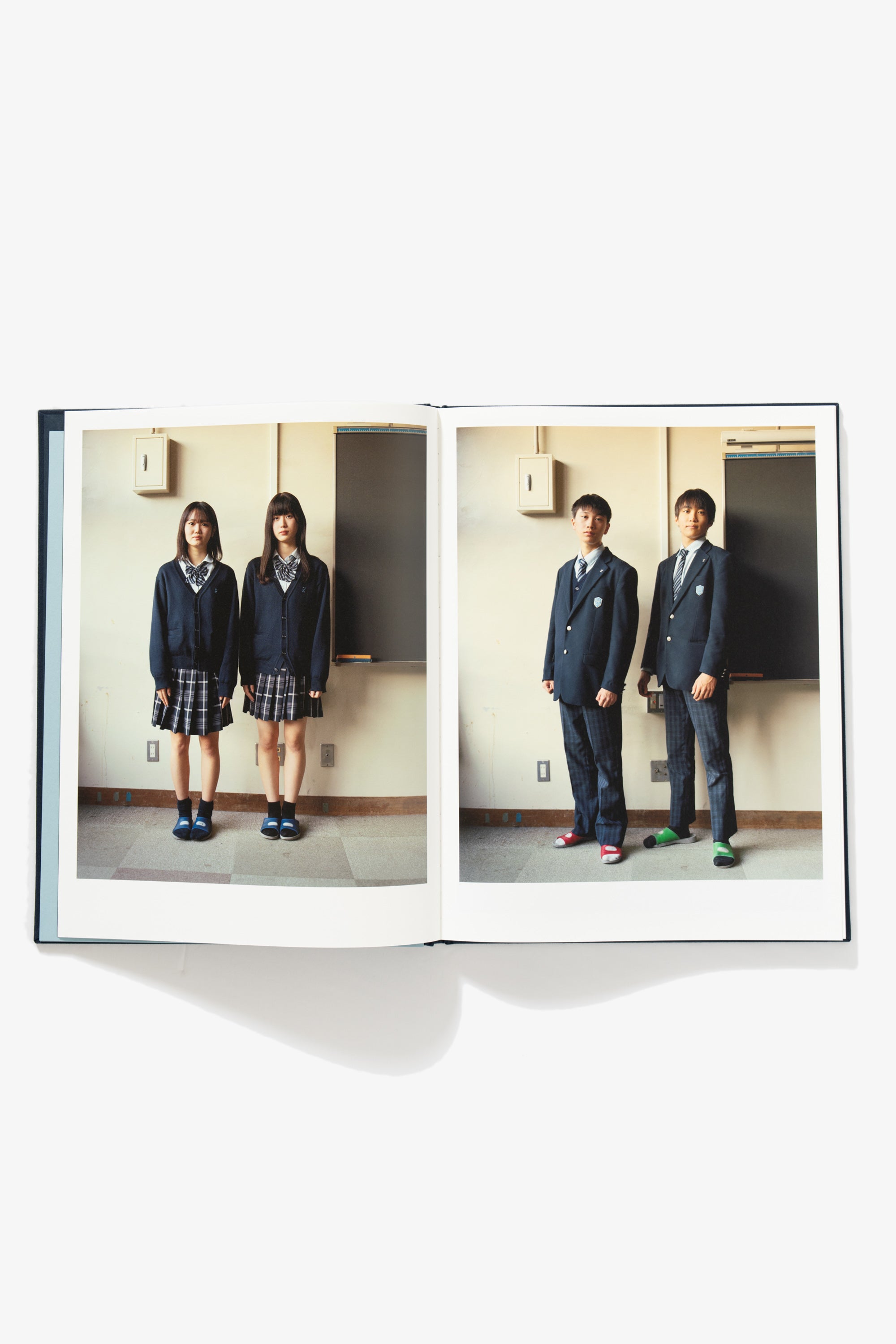 Spread of Goodbye Blue Spring. Verso shows two schoolgirls in uniform, of similar height, posing against a classroom wall. Recto mirrors this image, but with two school boys.
