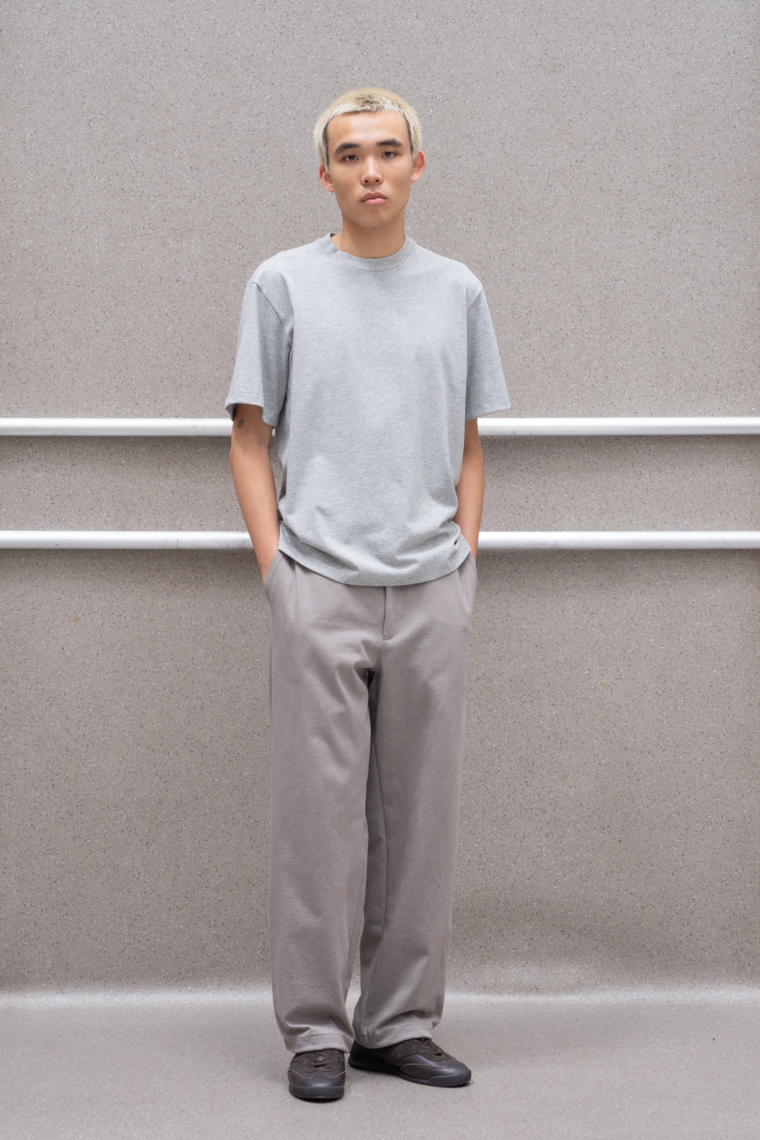 A model wears a LW141 Athens T-shirt in heather grey against a grey background, askew from the direct sight line.