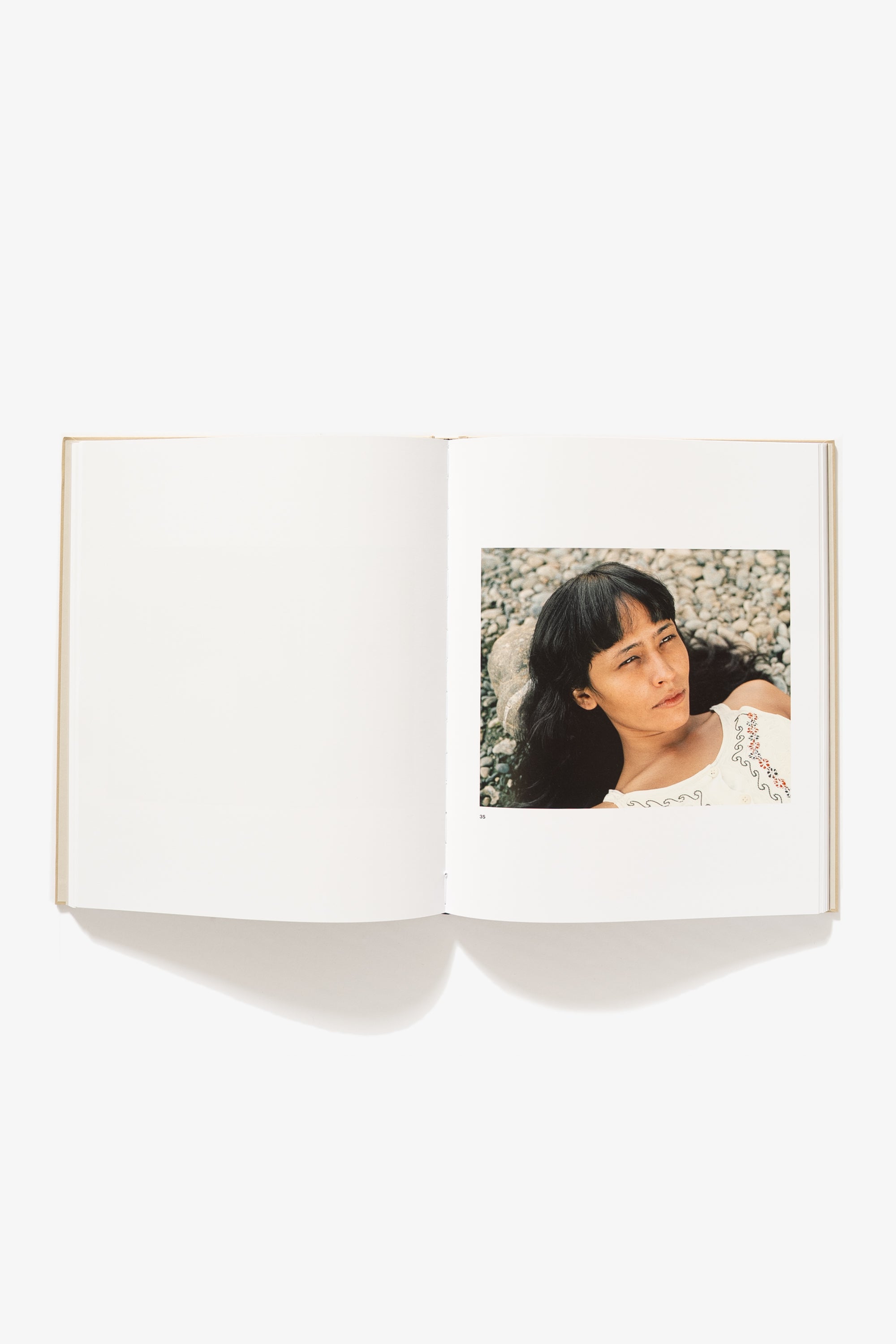 Photo of a spread in Felipe Romero Beltran's "Bravo." Verso is blank, right side shows a portrait of a woman resting her head on a rock, her hair flowing from the nape of her neck.