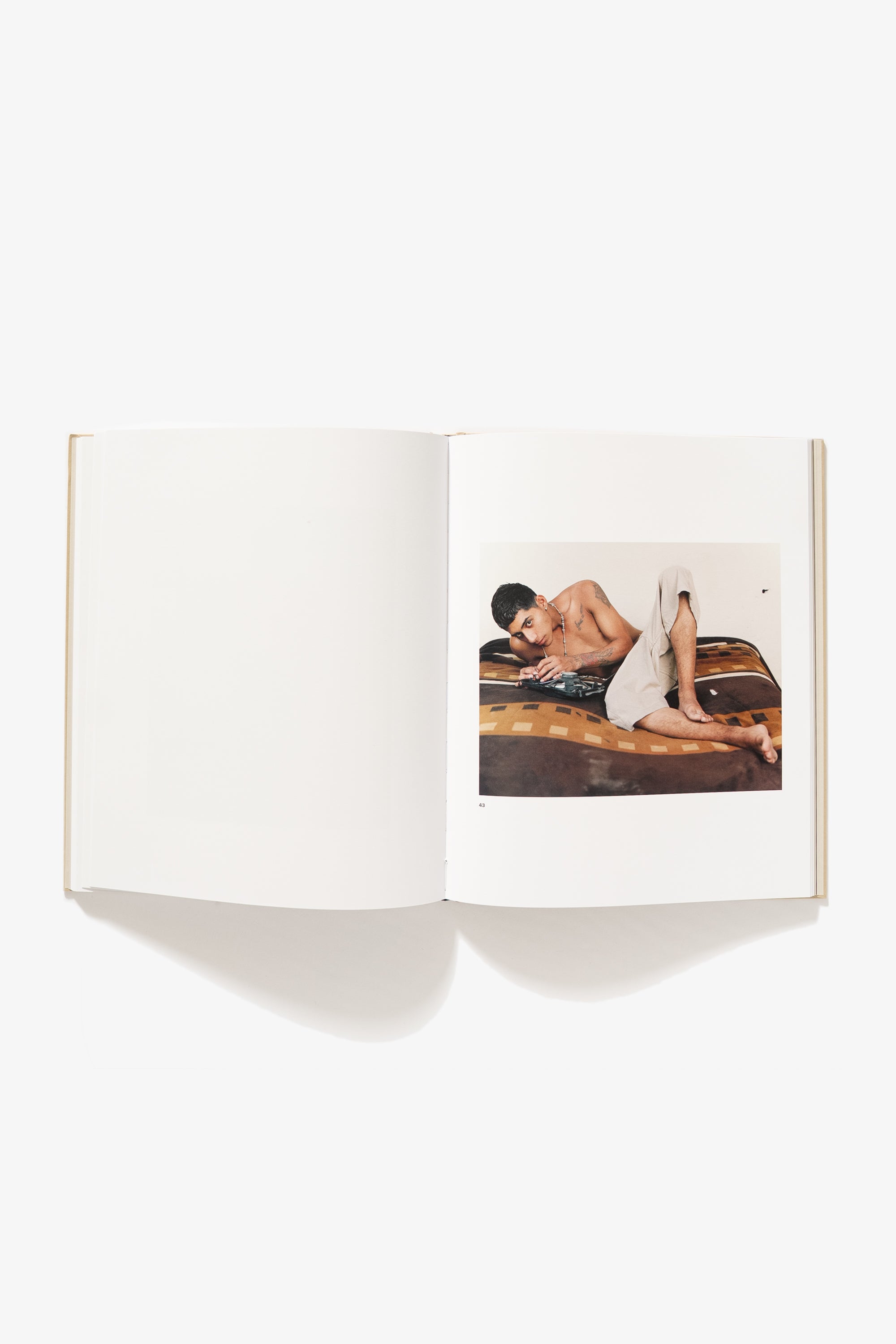 Spread from Felipe Romero Beltran's "Bravo." Verso blank, the recto displays a male figure resting on his side, one leg propped up halfway with his knee facing up, his face toward the camera.
