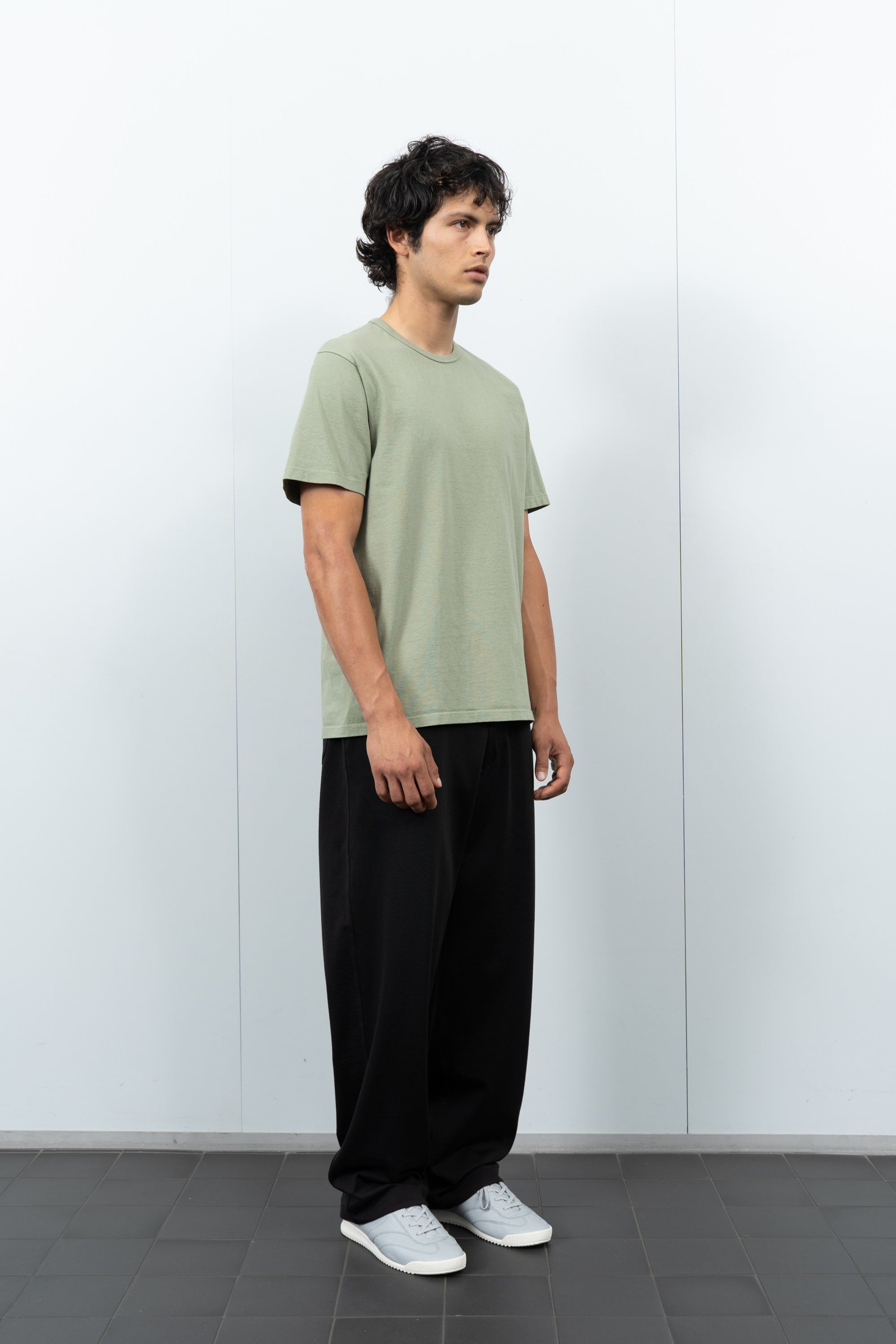 Quarter-turn rear-facing on-model photograph of model wearing LW101 Our T-shirt in Pistachio