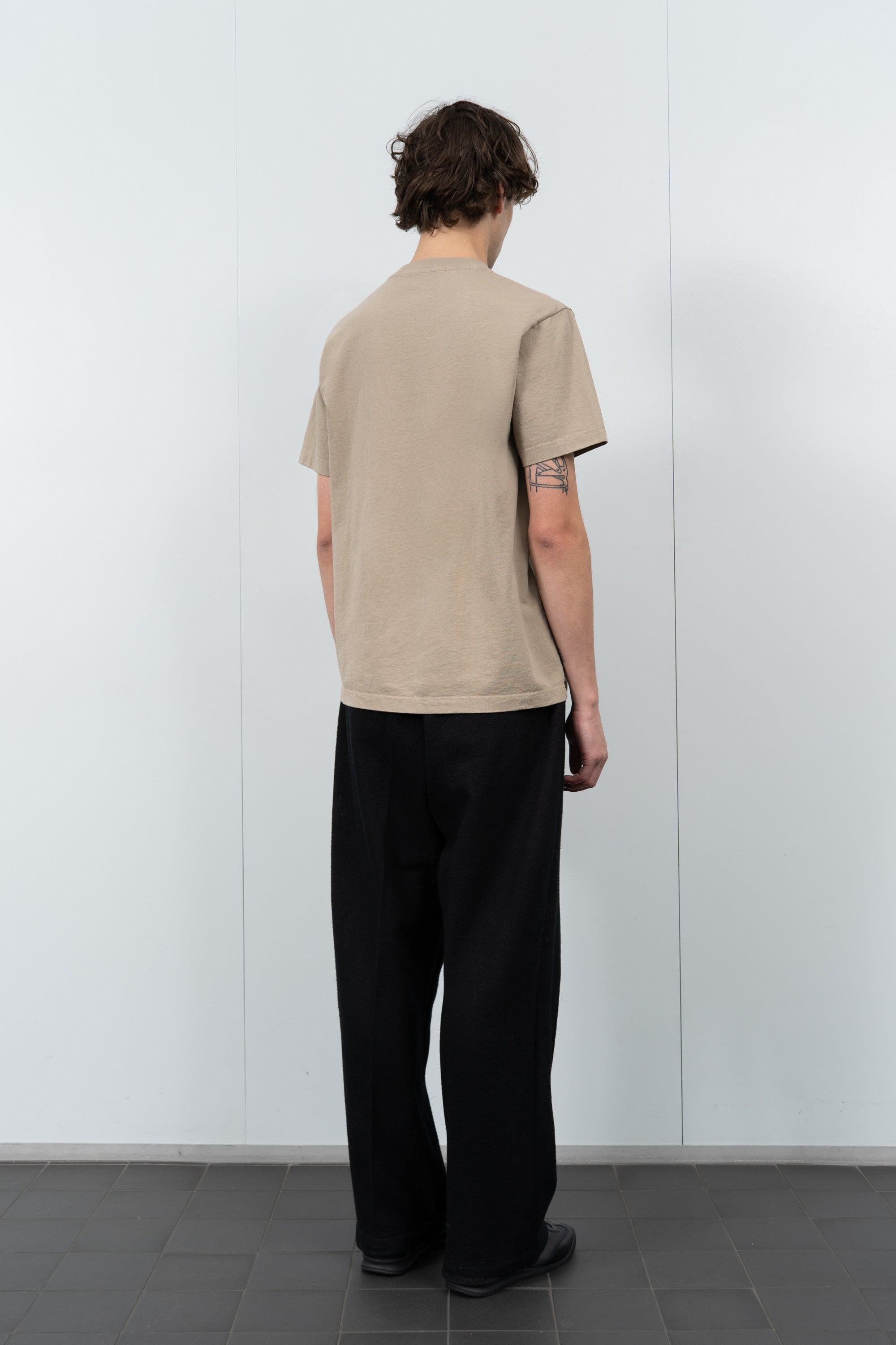 Model poses in LW102 Municipal T-shirt in sand