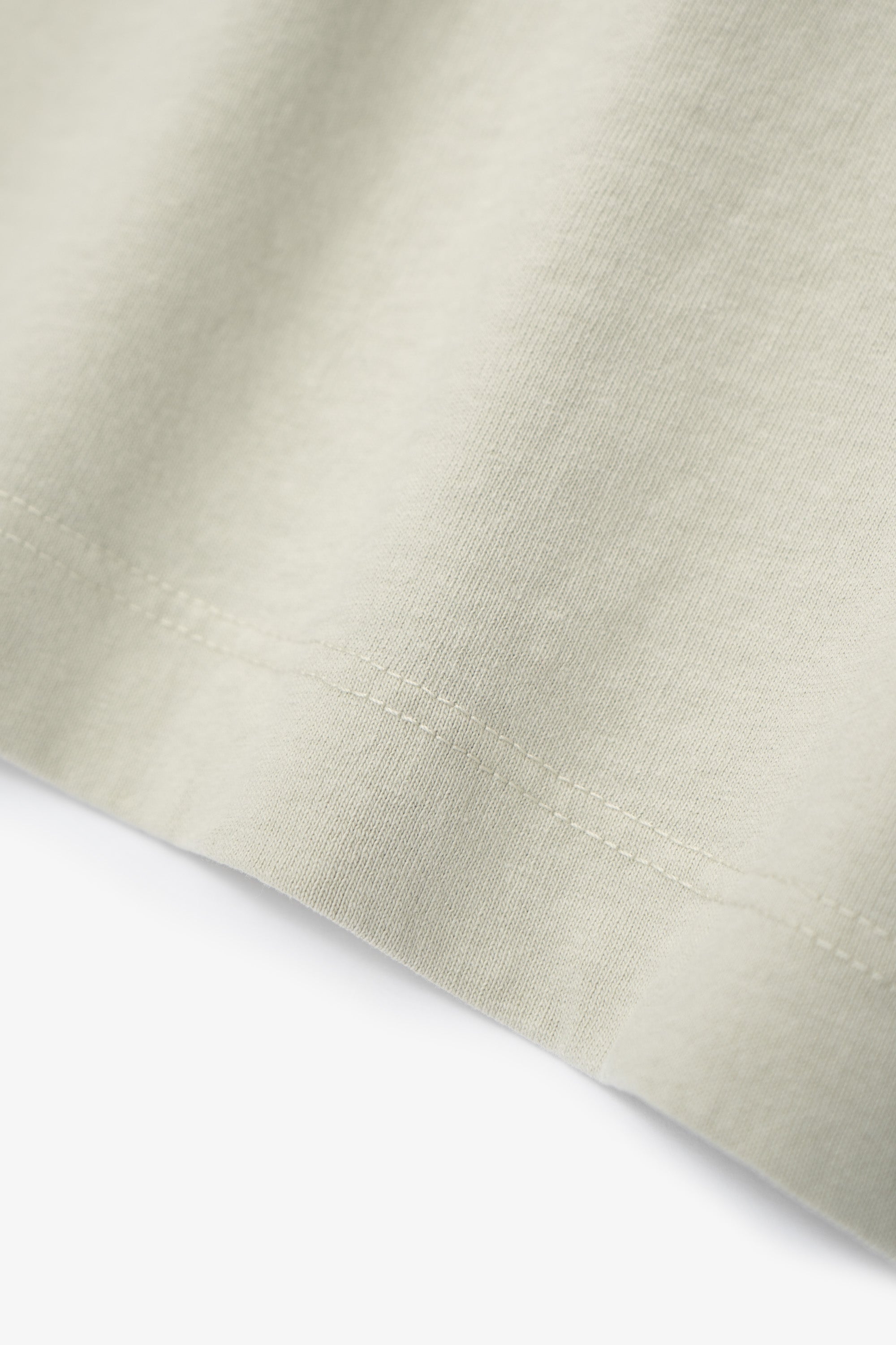 Hem detail of LW102 Municipal T-shirt in a creamy green, “Swiss Natural”