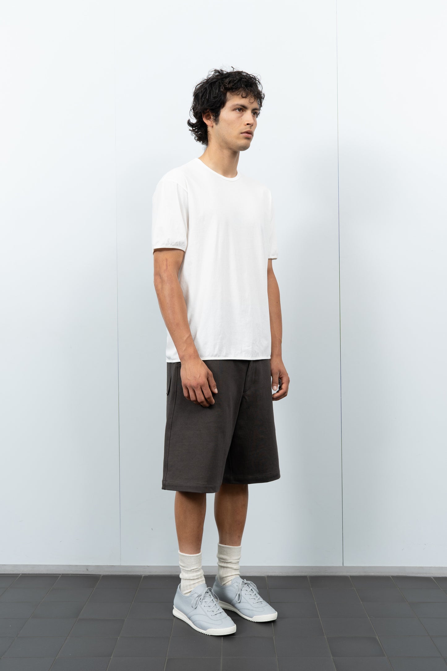 Quarter-turn rear-facing on-model photograph of model wearing LW110 Dry Lite T-shirt in White