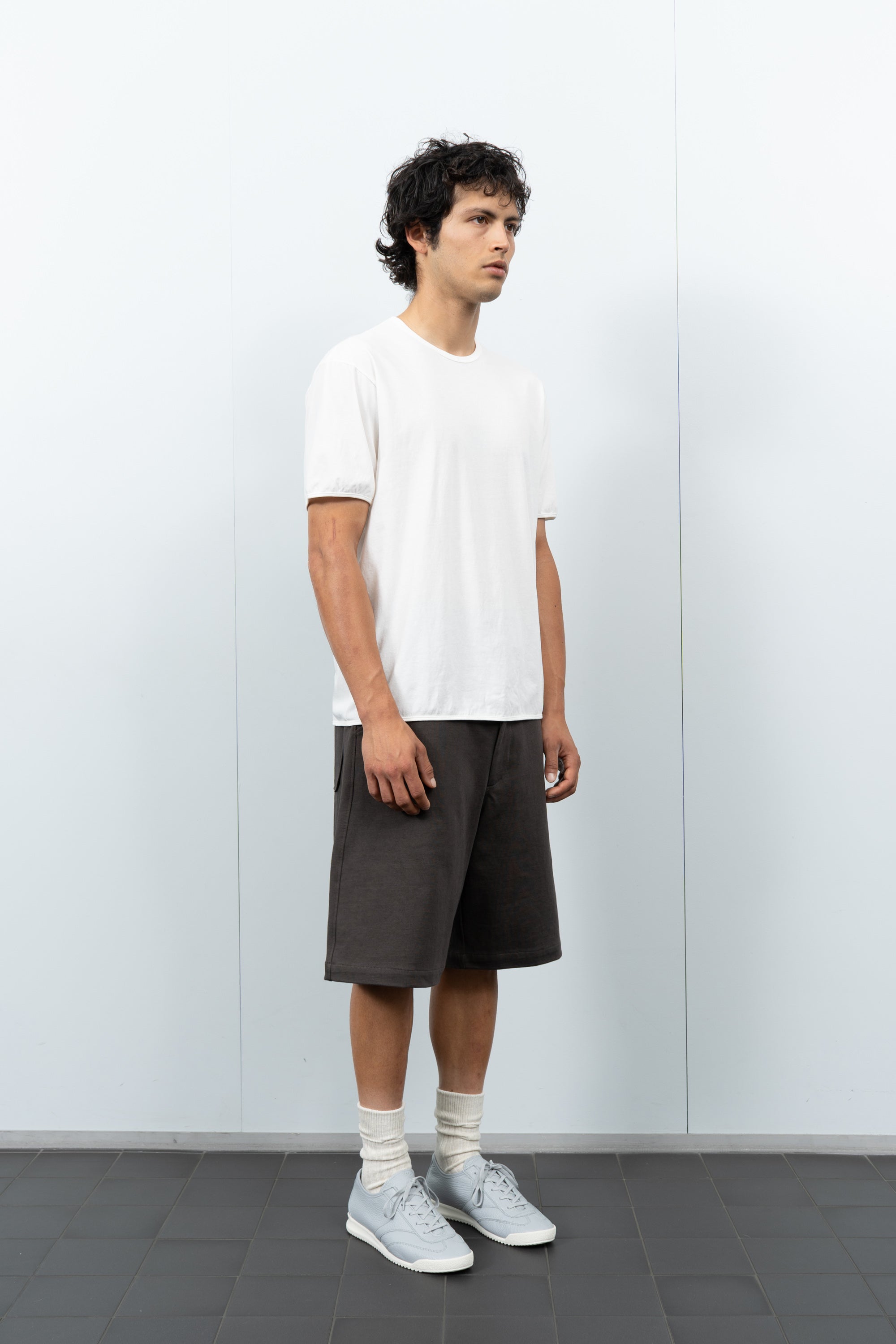 Quarter-turn rear-facing on-model photograph of model wearing LW110 Dry Lite T-shirt in White
