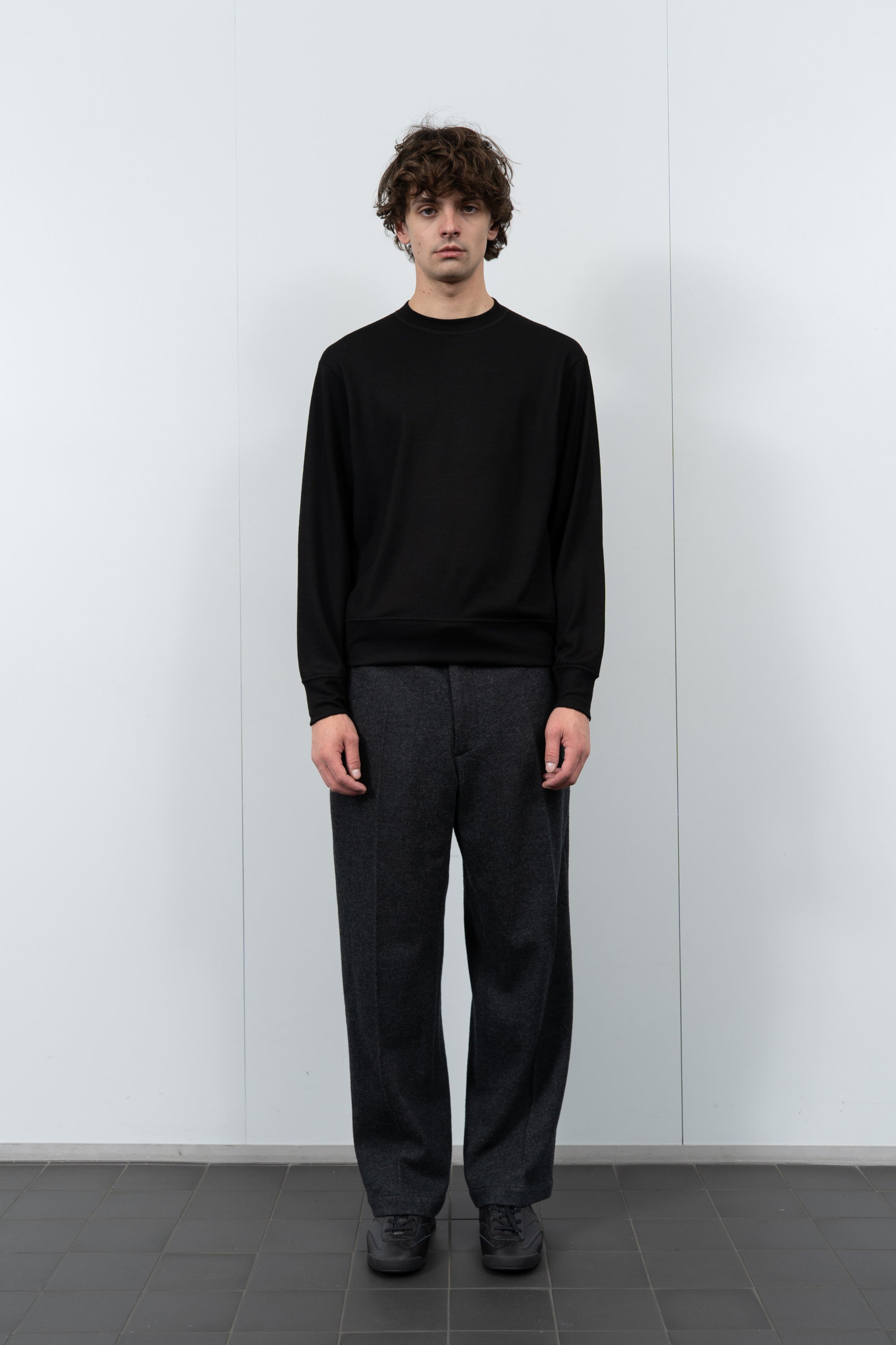 Model poses in LW601W Wool Jersey Sweater in black