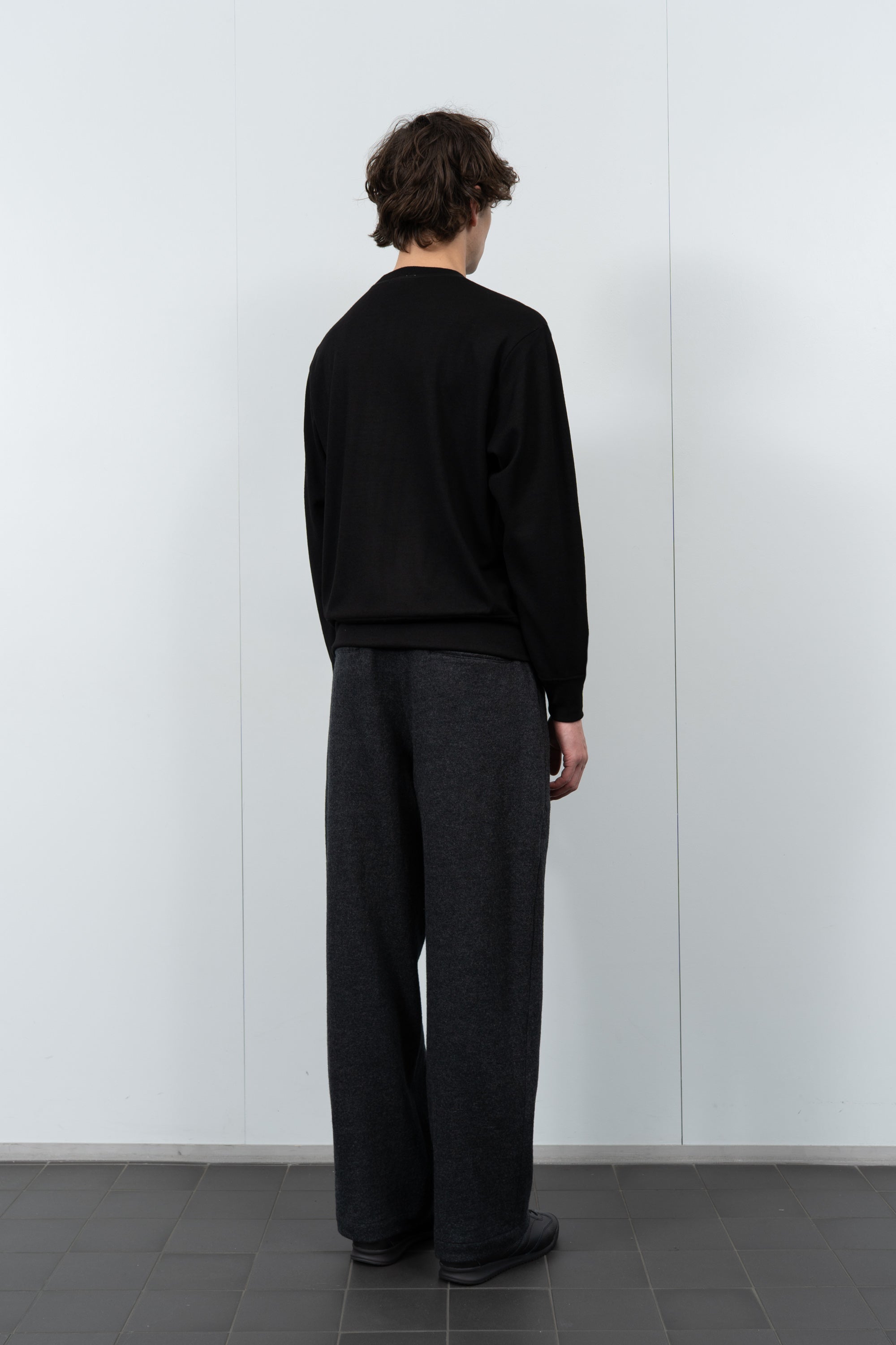Model poses in LW601W Wool Jersey Sweater in black