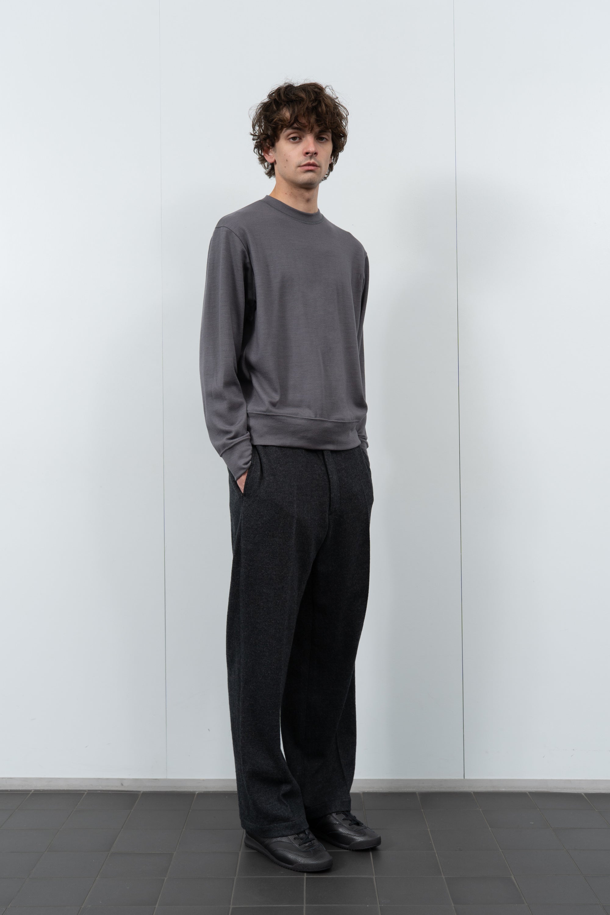 Model poses in LW601W Wool Jersey Sweater in slate grey