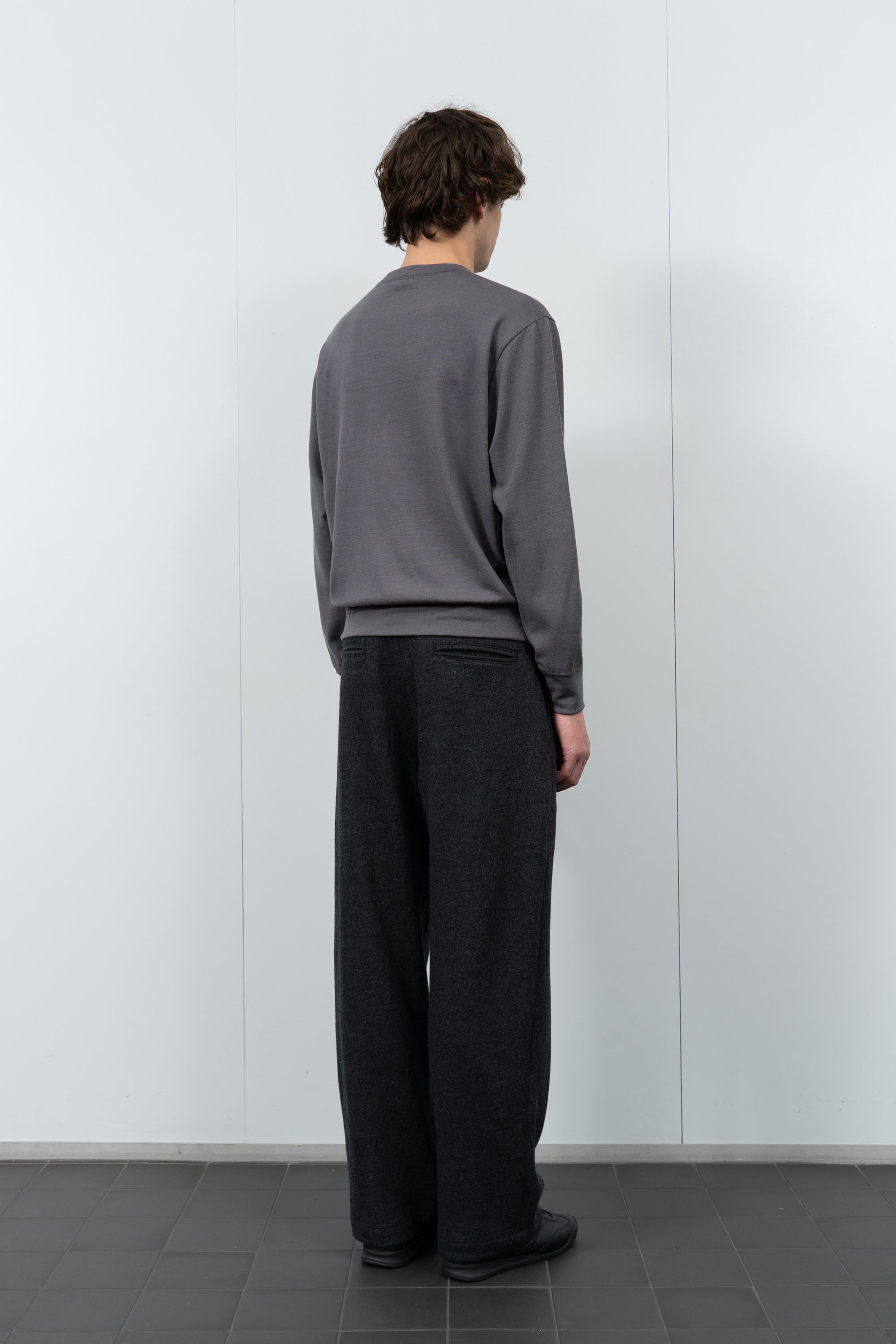 Model poses in LW601W Wool Jersey Sweater in slate grey