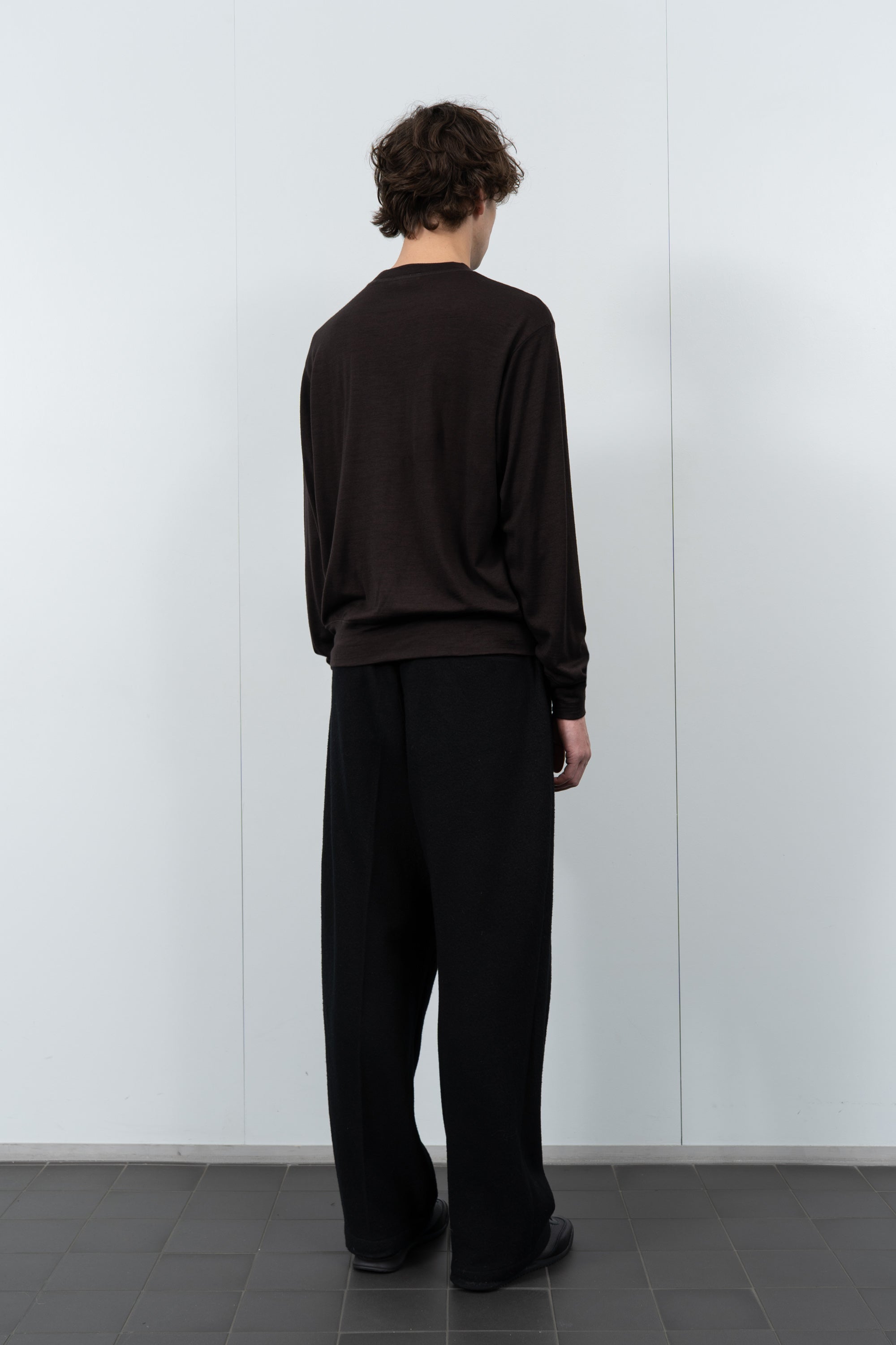 Model poses in LW601W Wool Jersey Sweater in Woodberry