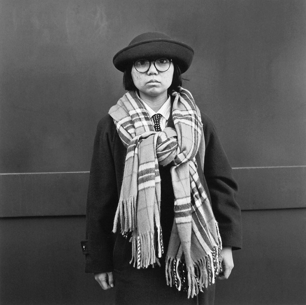 Photograph from Hiroh Kikai's "Asakusa Portraits." Portrait of a school girl, wearing an oversized patterned scarf, against a plain background.